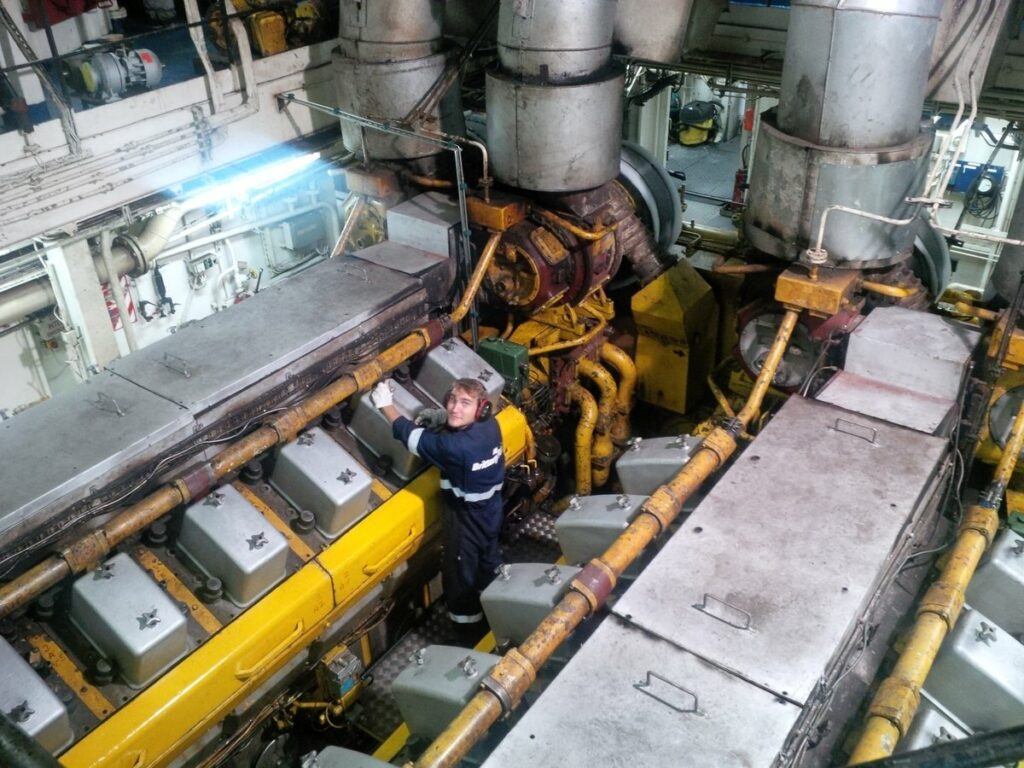 Deux des moteurs principaux de Bretagne sont photographiés, pendant qu'un mécanicien les entretient.