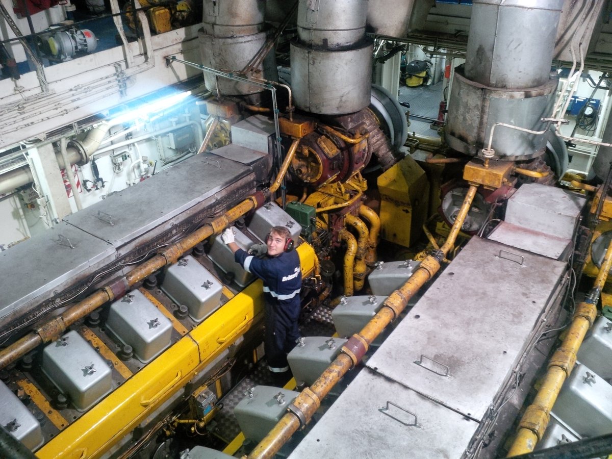 Deux des moteurs principaux de Bretagne sont photographiés, pendant qu'un mécanicien les entretient.