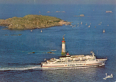 Carte postale du ferry Goëlo alors qu'il entre dans la baie de Saint-Malo. Il est photographié au large de l'île de Cézembre et du phare du Grand Jardin.