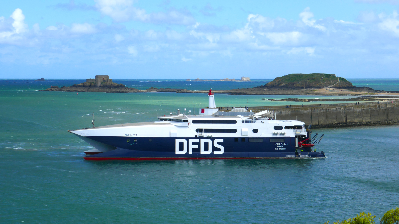 Le catamaran HSC Tarifa Jet recule dans le port de Saint-Malo. En arrière plan, figurent l'île du Petit Bé, l'île du Grand Bé et la jetée du Môle.