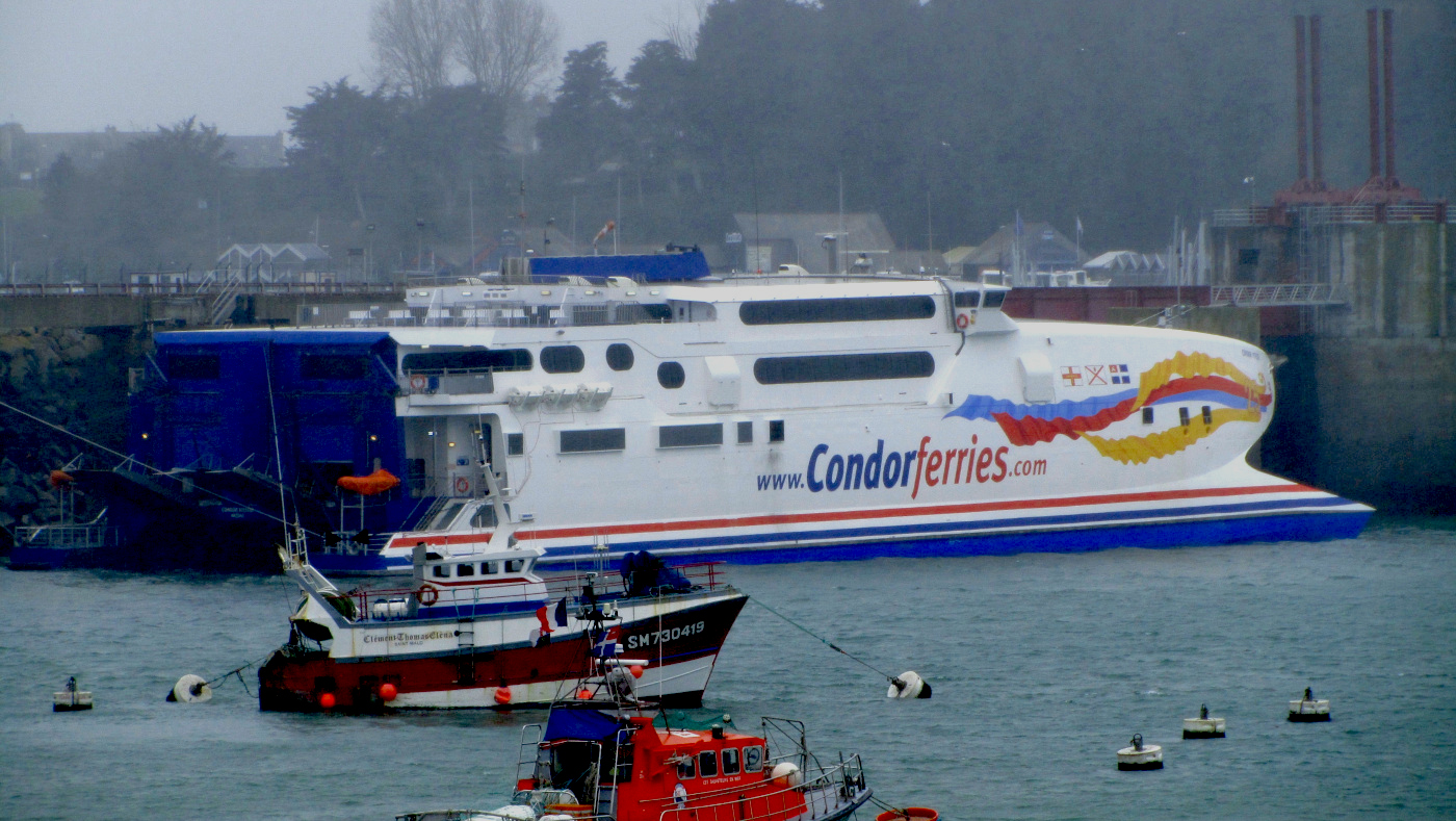 Le catamaran Condor Vitesse est appareillé dans le port de Saint-Malo, arborant la livrée commémorative des 25 ans de la ligne Weymouth - Îles Anglo-normandes.