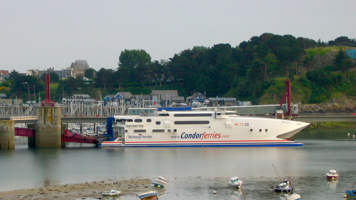 Le catamaran Condor Vitesse est amarré dans le port de Saint-Malo par basse mer.
