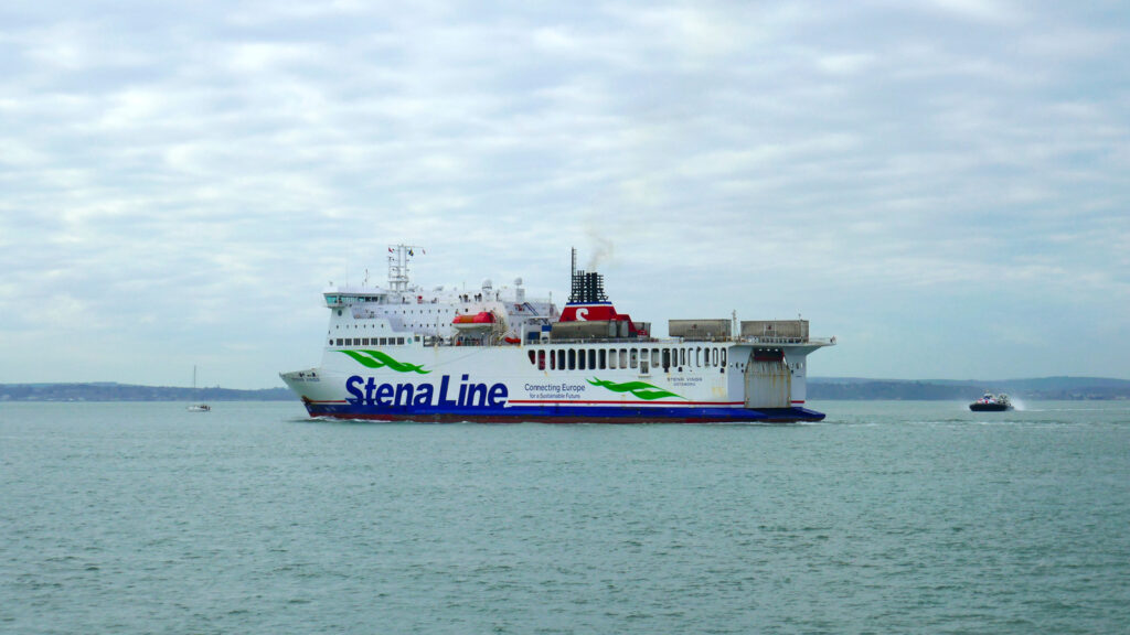 Le car-ferry M/V Stena Vinga, opéré pour le compte de DFDS, appareille de Portsmouth pour Jersey. Il passe devant la commune de Gosport. En arrière-plan, on voit l'un des deux appareils d'Hovertravel.